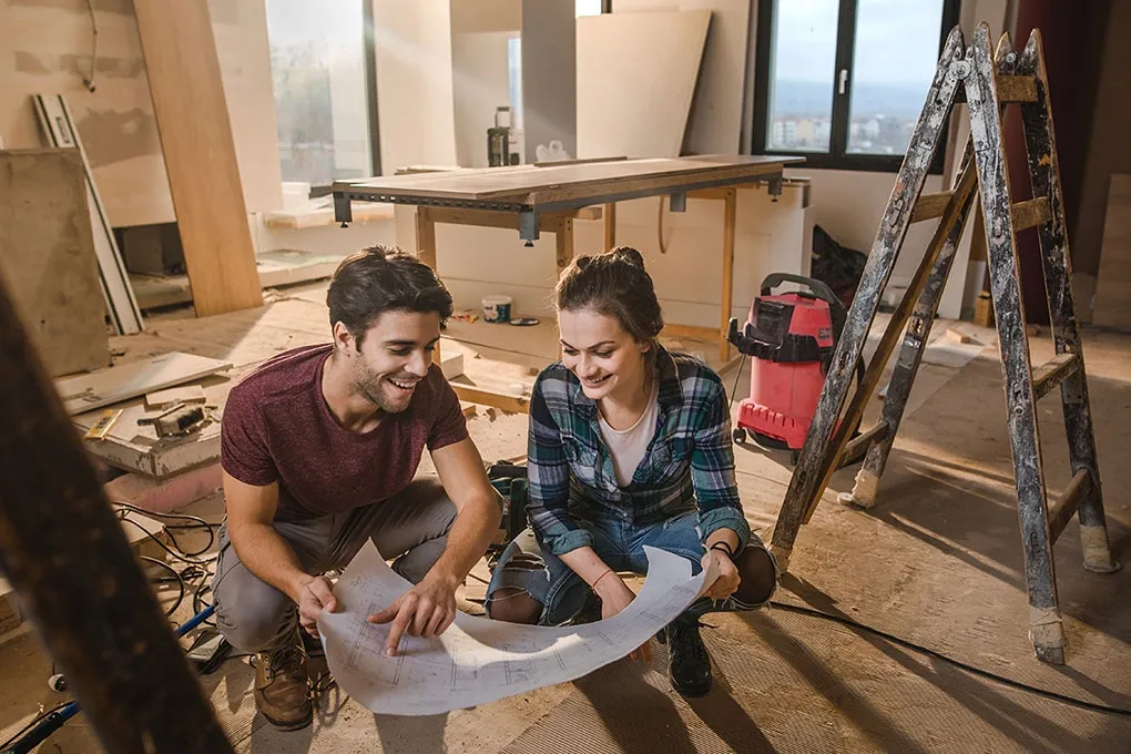 Homeowners reviewing renovation plans inside their home